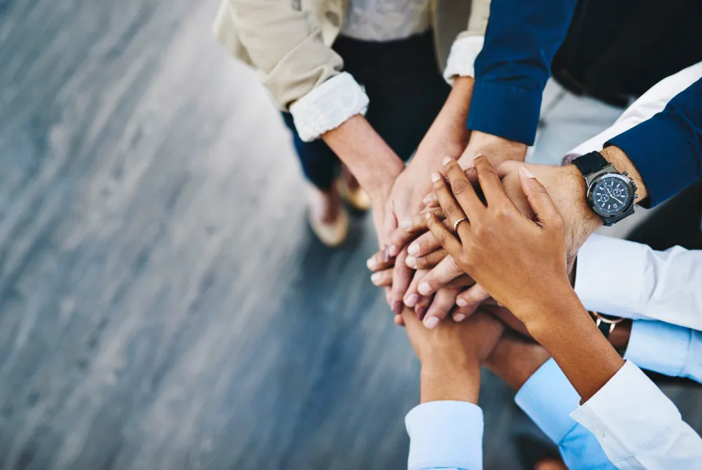 Hands stacked on top of each other in a team huddle